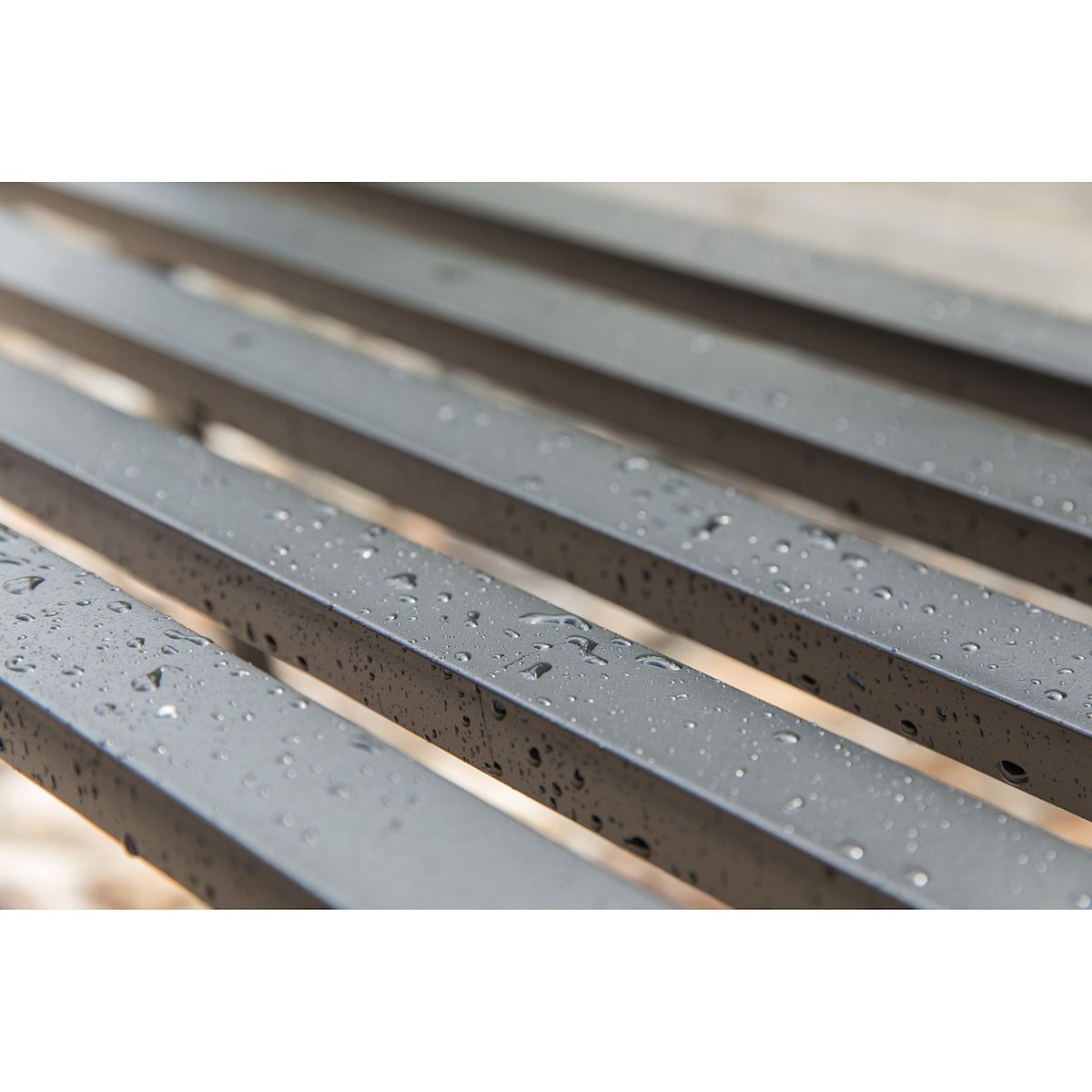 Close-up of textured black slatted seat bars on outdoor bench