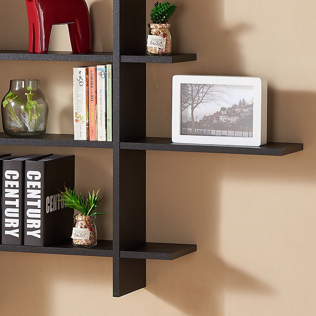 Five-level asymmetric wall shelf with decor and books arranged on shelves