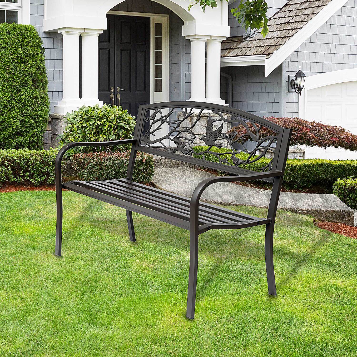 Metal garden bench outdoors with lush greenery