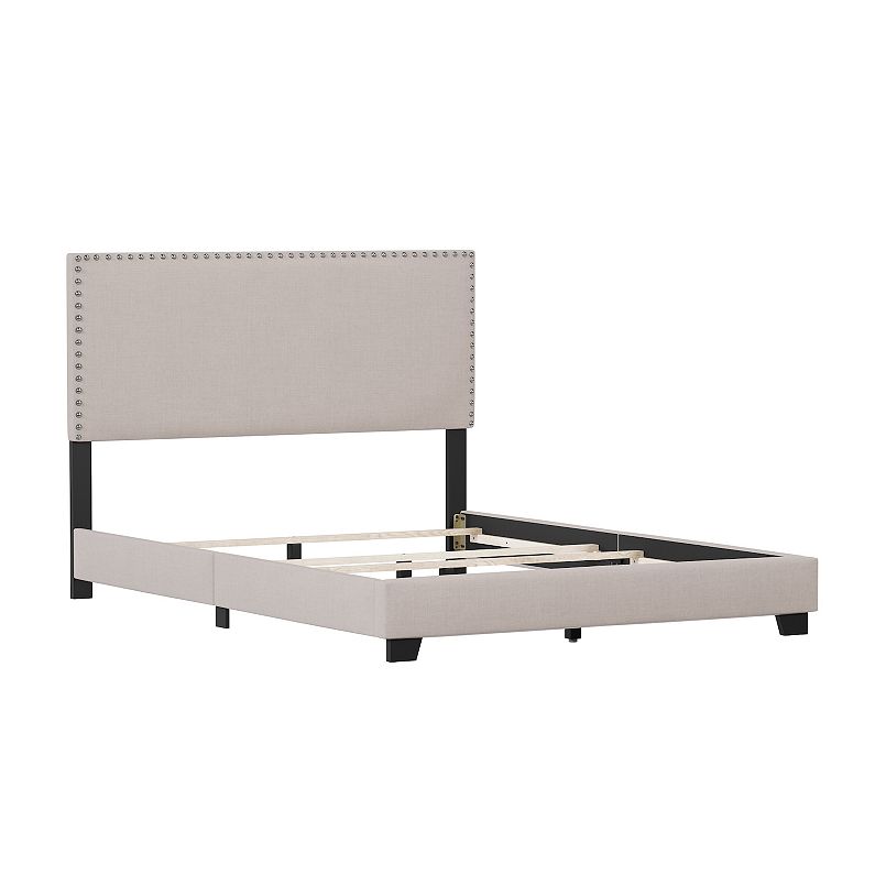 Beige upholstered bed frame with nailhead trim and low profile footboard