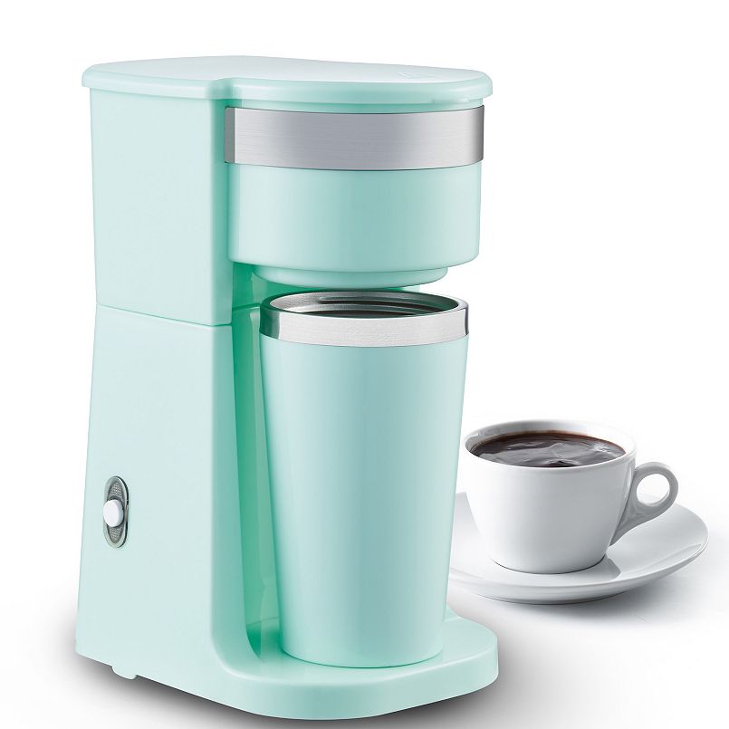 A blue single cup coffee maker with matching travel mug next to a white mug of coffee on a plate