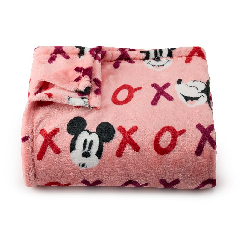 A pink blanket covered in purple and red X’s and O’s and Mickey Mouse faces