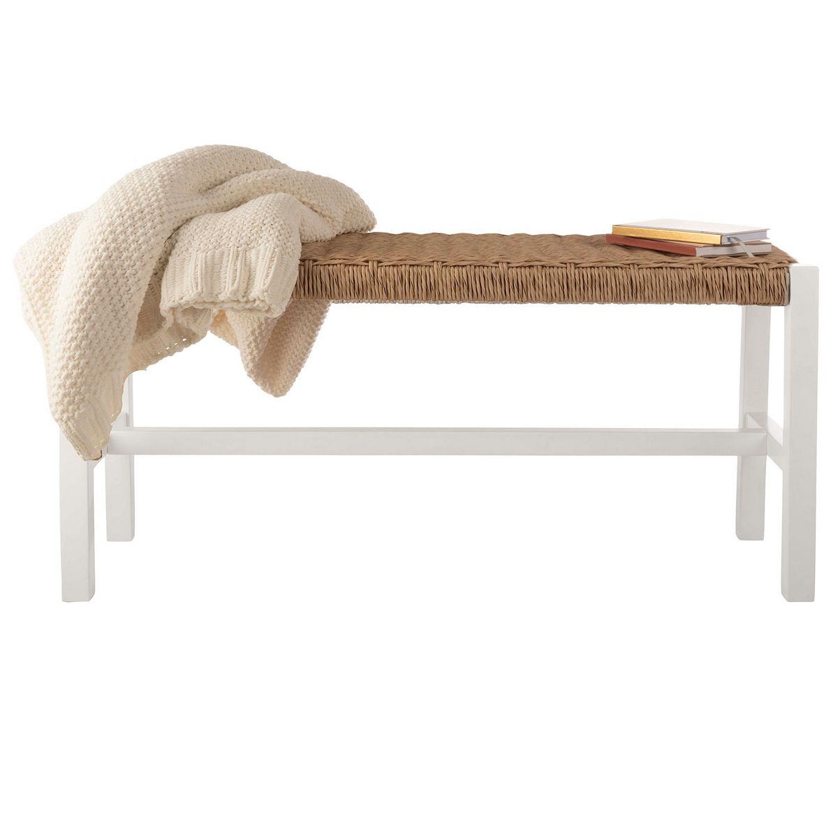 White entryway bench with woven rattan seat styled with throw and books