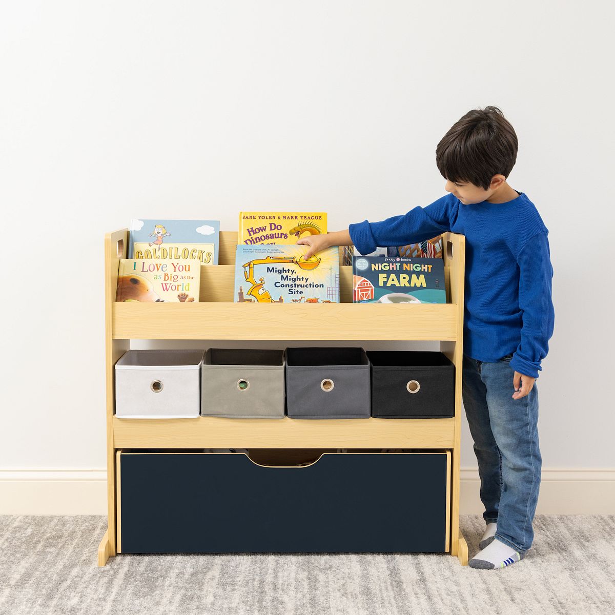 Child standing by Humble Crew 3-in-1 storage cabinet with book storage