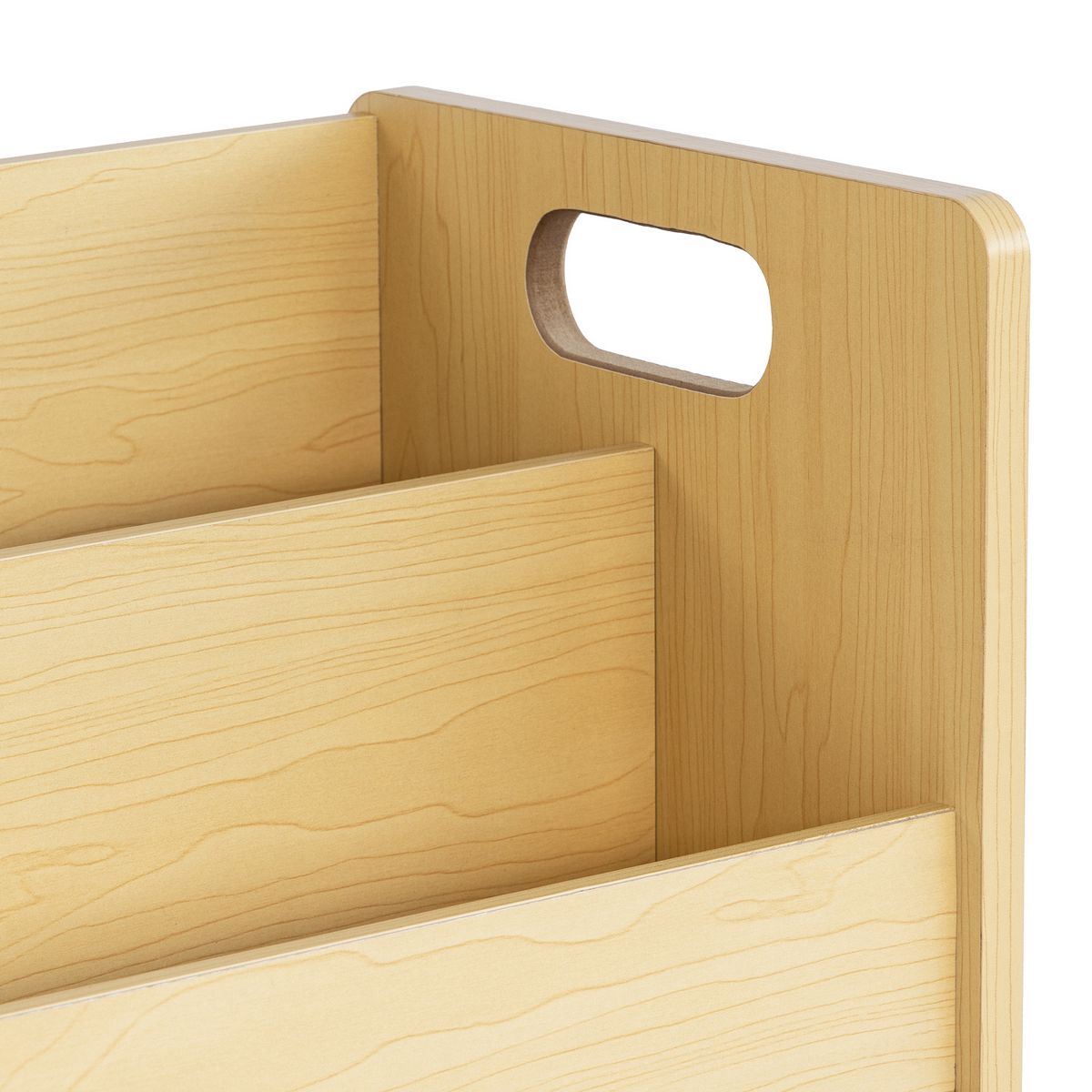 Close-up of curved handle cutout on side of light wood storage cabinet