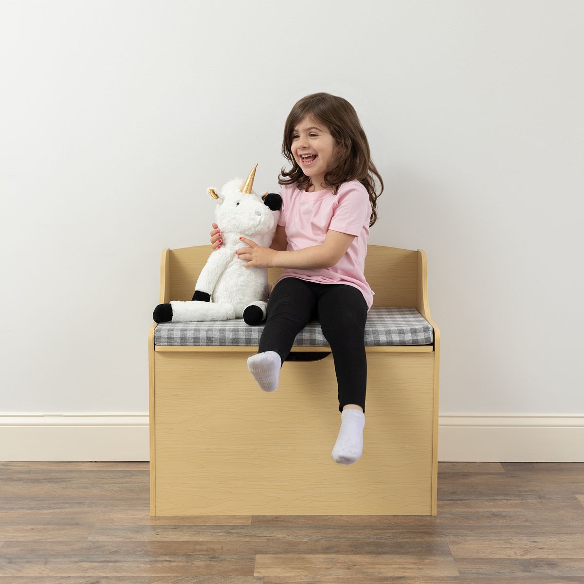 Child relaxing on Humble Crew hinged toy storage bench
