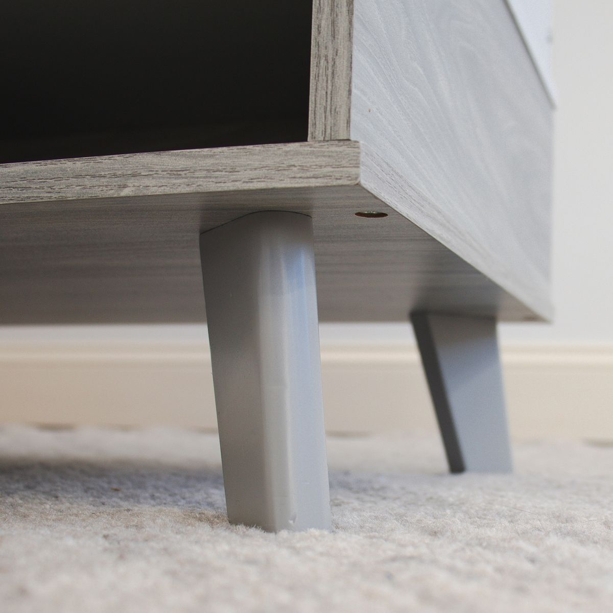 Close-up of Humble Crew toy box legs and bottom shelf