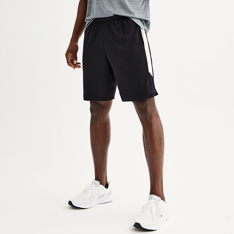 A man wearing black shorts with a white stripe down the side