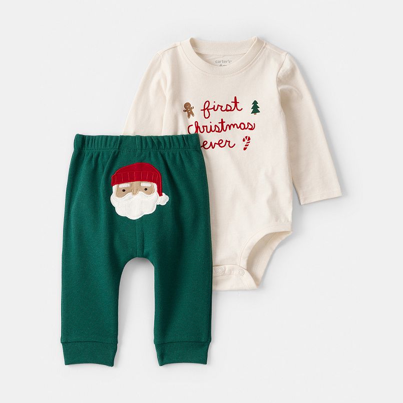 A white bodysuit with red text and green pants with a Santa face on them
