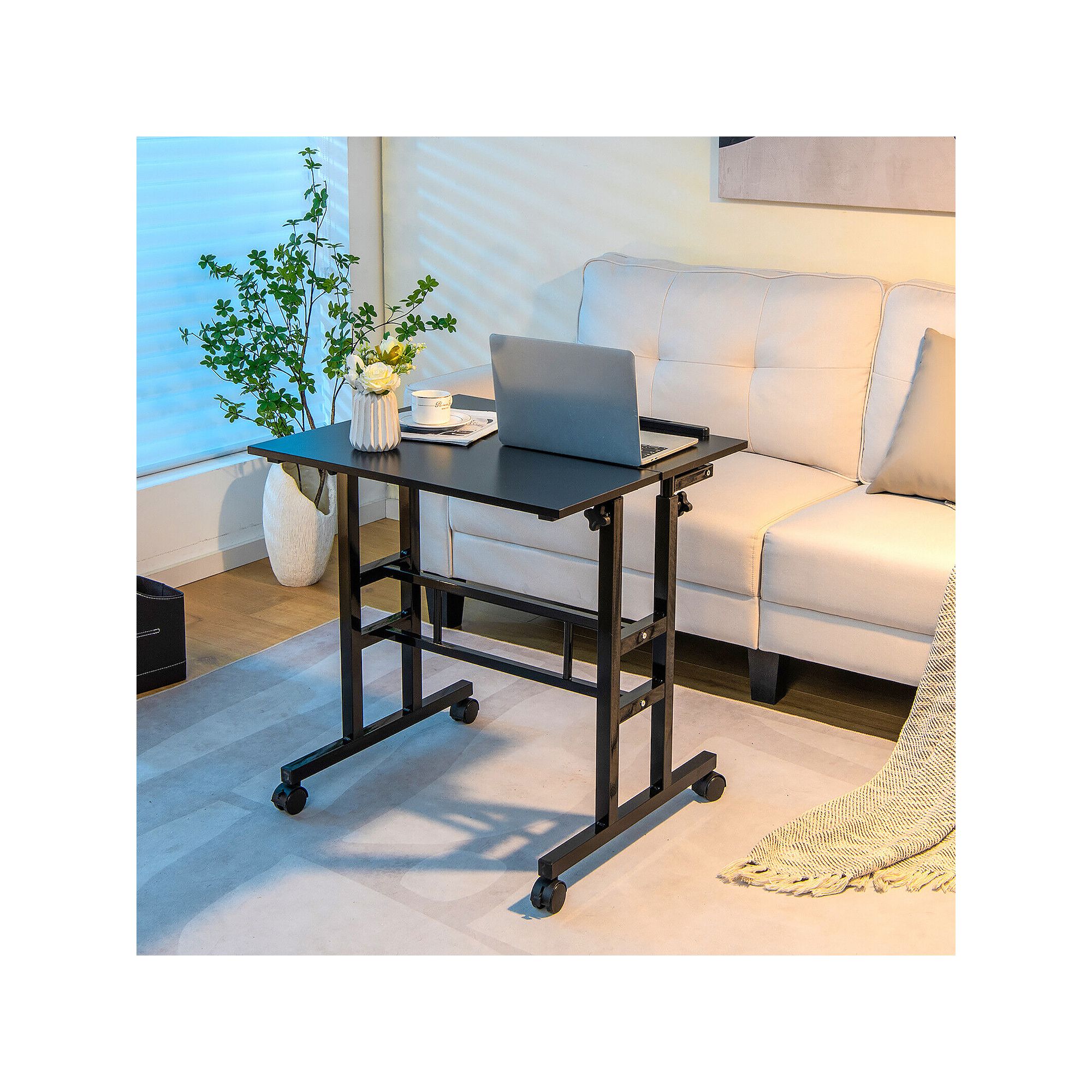 Black adjustable tilting mobile stand-up desk beside a sofa