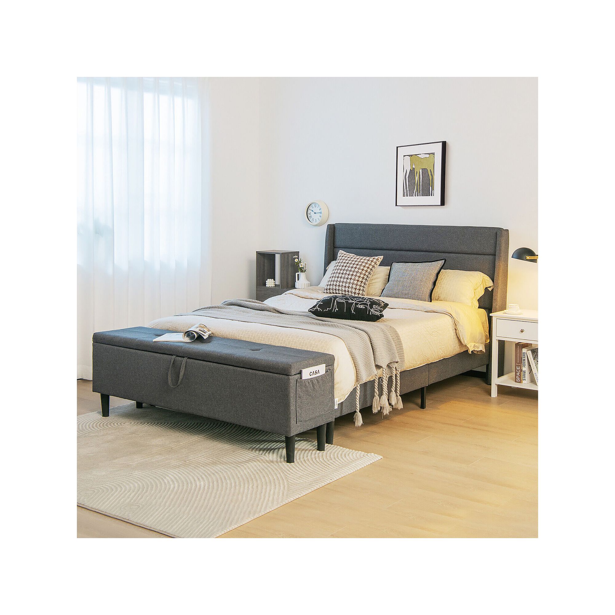Dark gray upholstered platform bed frame with open storage ottoman and tall headboard