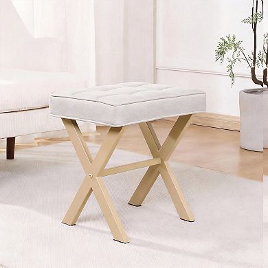 A compact stool with a padded seat and a metal X-shaped base; a vanity stool.