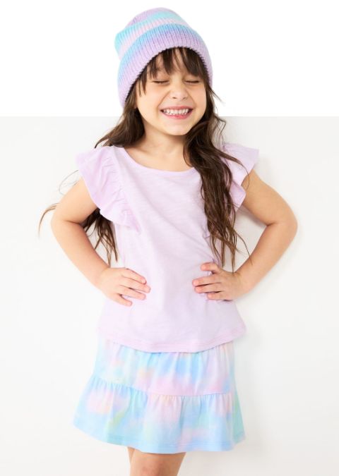 Girl wearing knit hat with shirt and skirt in matching pastel colors