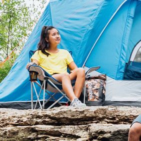 girl seated in folding camp chair