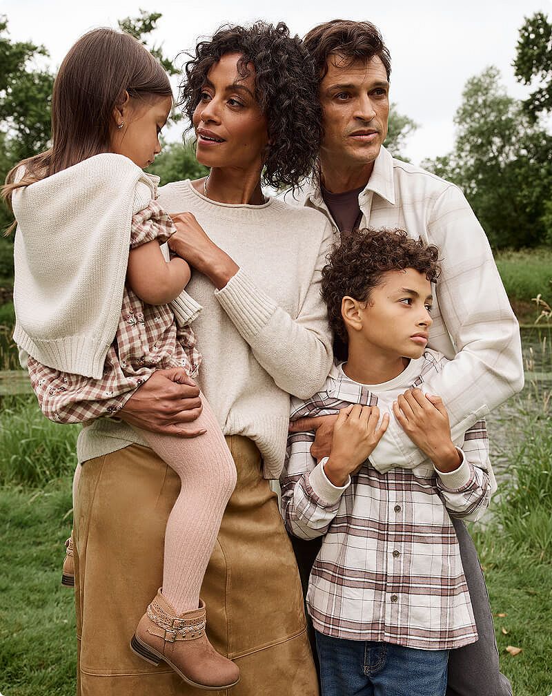 Family posing outdoors in fall clothing