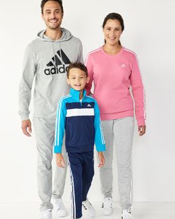 Lifestyle image of two parents and child wearing all adidas athleticwear